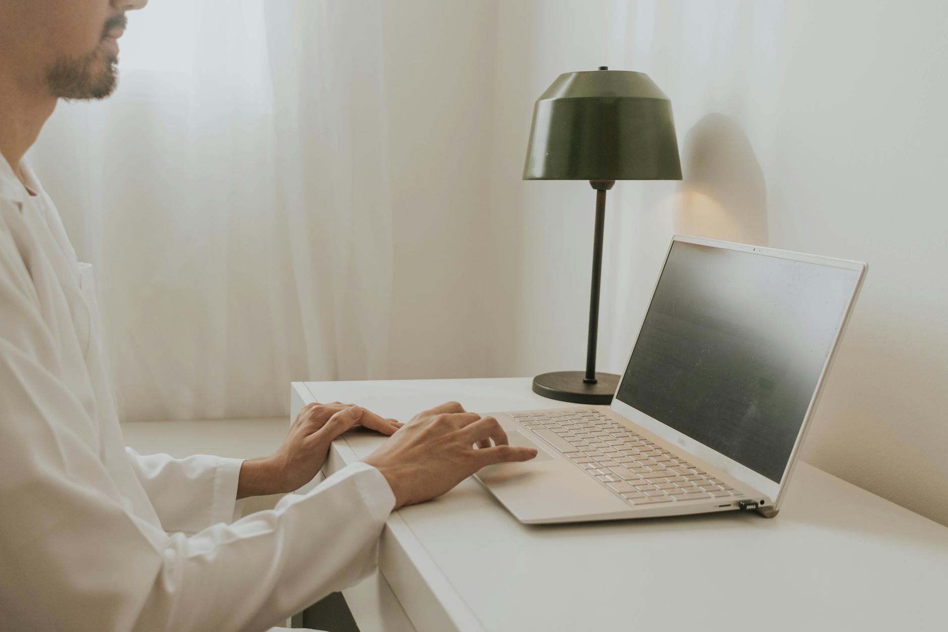 man sitting by laptop and working